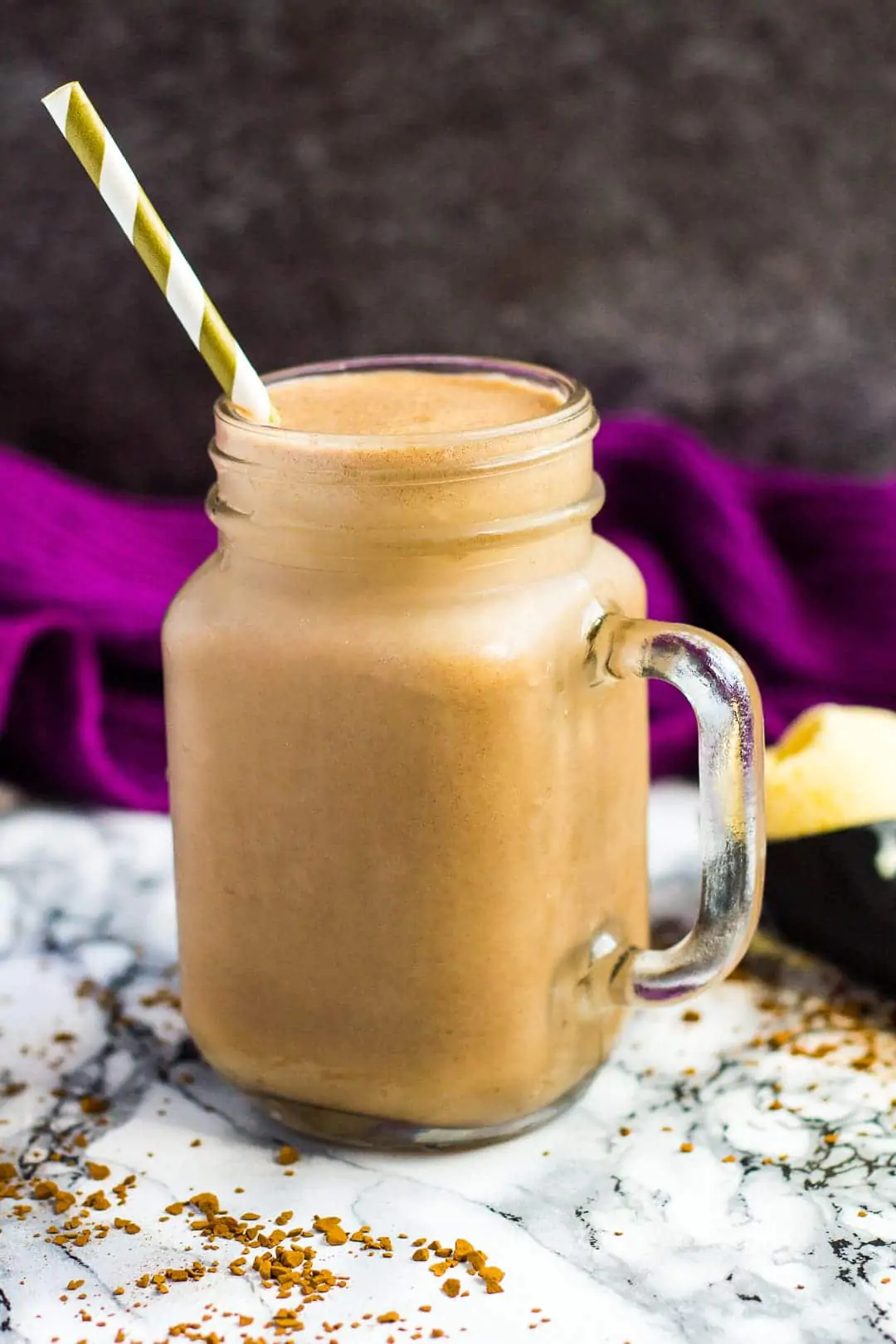 A mason jar filled with Nutella coffee milkshake with a straw.