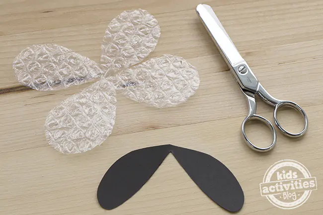 Firefly wings cut of bubble wrap and black construction paper with a pair of steel scissors.