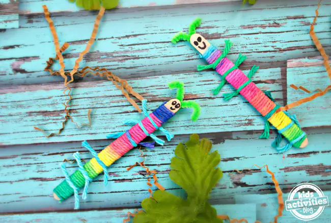 Craft Stick Caterpillars finished with marker drawn faces and pipe cleaner antennae - Kids Activities Blog
