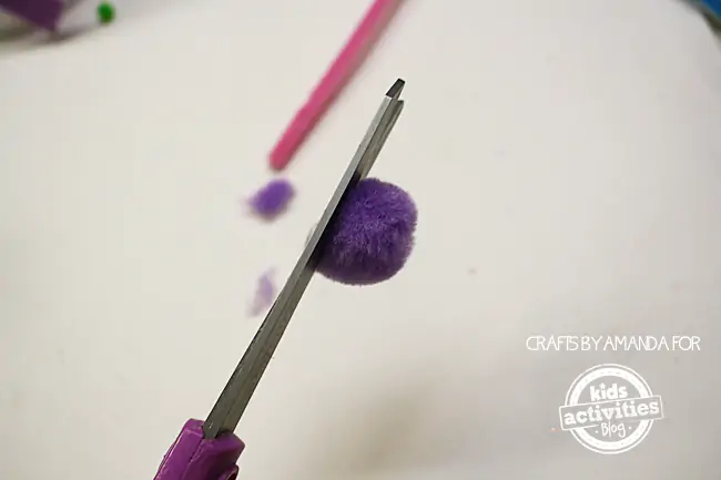 Step 5 - cutting a pom pom to have a flat pom pom edge for Snowman Craft from Foam Cups